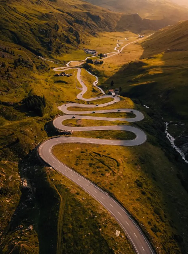 Aerial view of a switchback mountain road in Switzerland in warm light